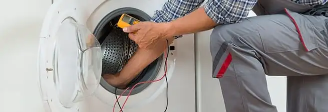 Dryer repair technician inspecting and repairing a clothes dryer in San Francisco, CA
