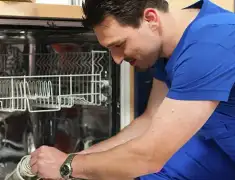 Dishwasher repair technician inspecting and servicing an open dishwasher in San Francisco, CA