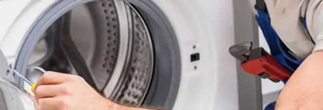 Appliance technician repairing a clothes dryer drum and internal parts in San Francisco, CA