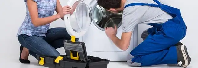 Washer repair technician inspecting a front-load washing machine with tools in San Francisco, CA