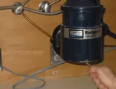 Garbage disposal repair technician tightening the mounting ring under a sink in San Francisco, CA