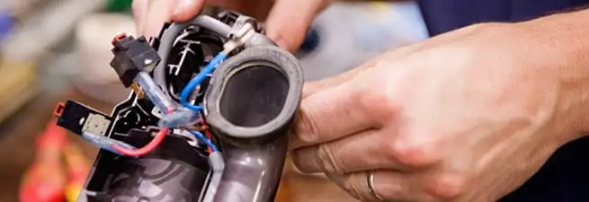 Vacuum repair technician reconnecting wiring and components in San Francisco, CA