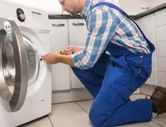 Washing machine repair technician servicing a front-load washer in San Francisco, CA