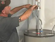Water heater repair technician tightening supply line connections in San Francisco, CA