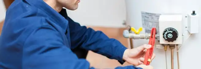 Water heater repair technician adjusting the temperature control and gas valve in San Francisco, CA